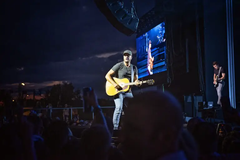 Luke Bryan strums his guitar on stage during a concert. 