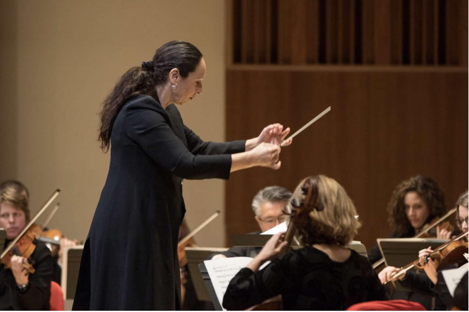 Female conductor conducts chamber orchestra