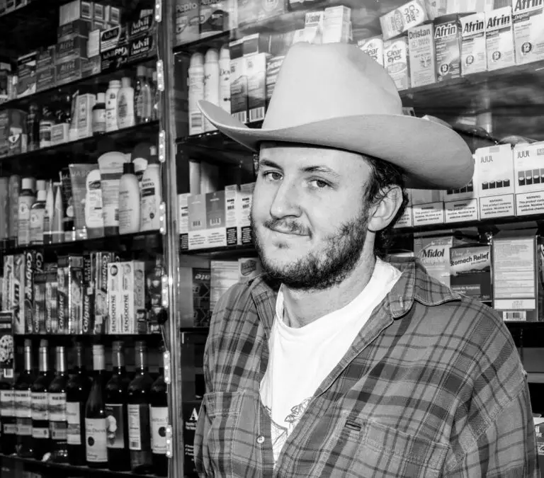 Black and white closeup shot of Dougie Poole wearing a cowboy hat and flannel shirt.