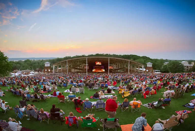 Aerial shot of rows upon rows of people watching a CMAC performance from seating in the grass.