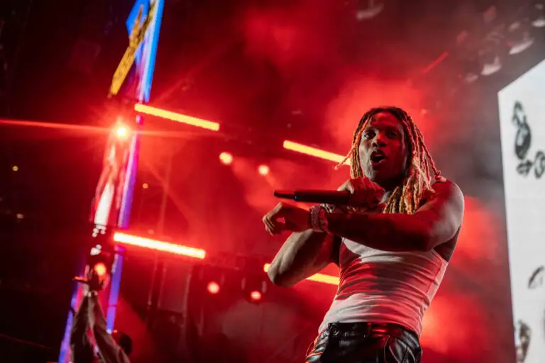 Rapper Lil Durk dances with a microphone in his hand during a live performance.