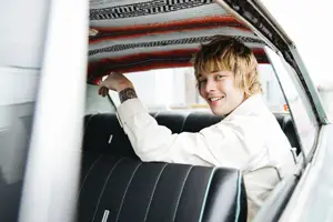 Billy Strings smiling in back of a car