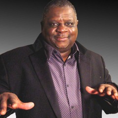 Reggie Seigler, a stocky middle-age/older black man wearing a purple dress shirt and black blazer.