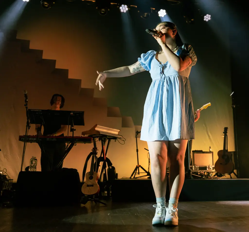 mxmtoon with her hand outstretched on stage at Webster Hall