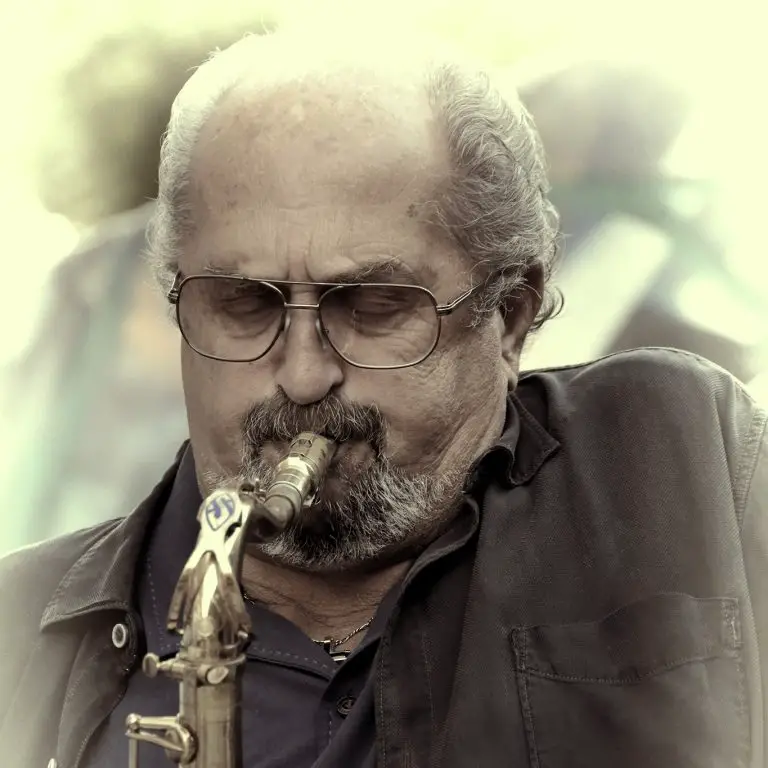 Jazz Musician Phil DiRe pays a gold tenor saxophone on stage. 