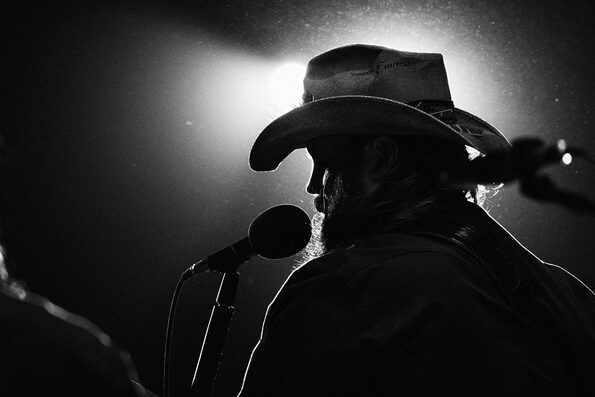 chris stapleton in black and white singing into microphone