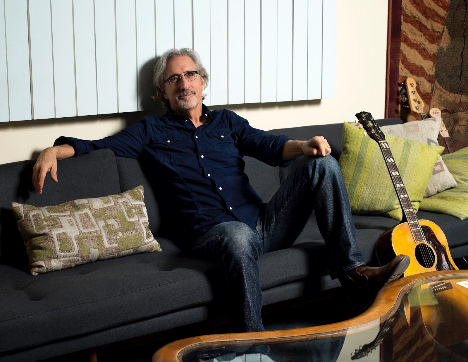 John Leventhal sitting on couch by guitar