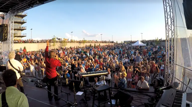 photo of band on stage at Harbor Jam looking out at full crowd from behind the band