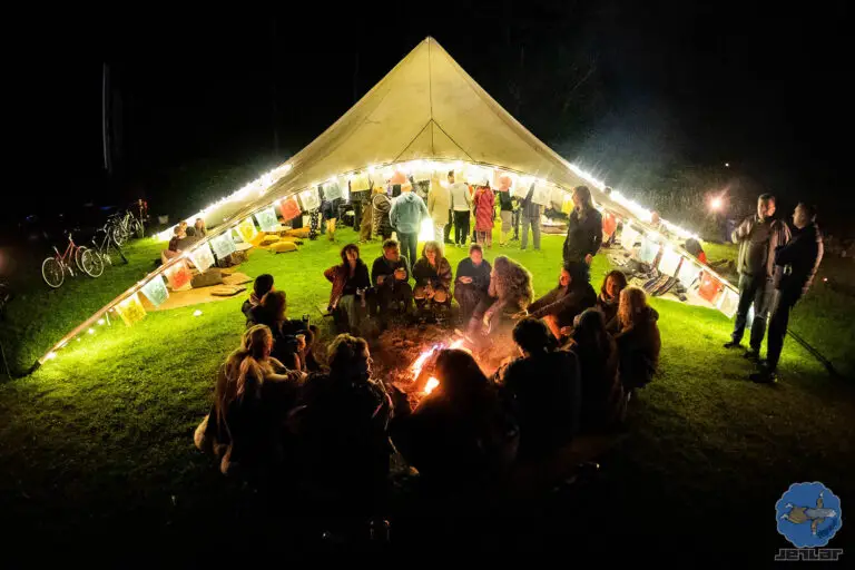 Group of festival attendees around fire at Chai station theme camp