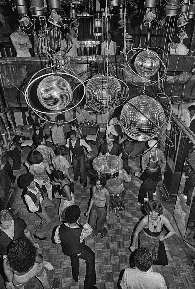 The late-70s NYC disco scene captured from the balcony—light, movement, and endless glitter at Reflections.