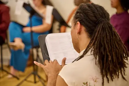 A performer signing to music in rehearsal